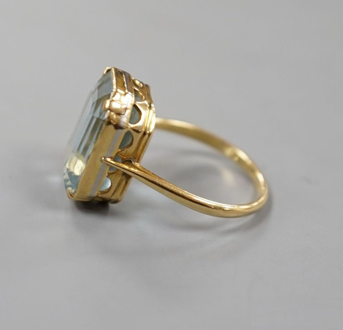 A yellow metal and single stone emerald cut aquamarine set dress ring, size K/L, gross 5.8 grams.